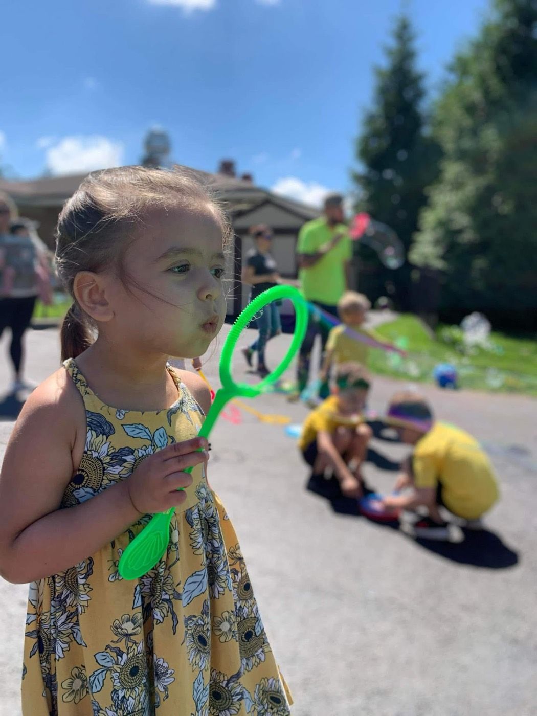 A girl blowing bubbles outside on bubble day