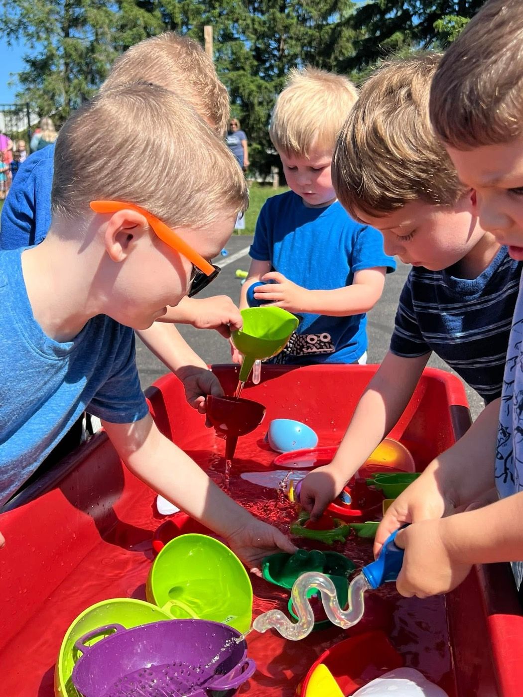 Children playing together at the water table on a sunny day at Open Arms